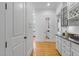 Hallway featuring hardwood floors, access to a butler's pantry, and white trim at 3016 Allansford Ln, Raleigh, NC 27613