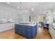 Spacious kitchen boasts a blue center island, hardwood floors, white cabinets and stainless steel appliances at 3016 Allansford Ln, Raleigh, NC 27613