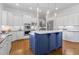 Modern kitchen featuring white cabinets, a center island, stainless steel appliances and hardwood floors at 3016 Allansford Ln, Raleigh, NC 27613