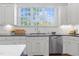 The kitchen features white cabinetry, stainless steel appliances, a large window, and beautiful countertops at 3016 Allansford Ln, Raleigh, NC 27613