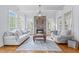 Sun-filled living room boasting a stone fireplace, hardwood floors, and expansive windows at 3016 Allansford Ln, Raleigh, NC 27613