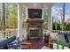 Outdoor fireplace and seating area overlooking wooded backyard at 3016 Allansford Ln, Raleigh, NC 27613
