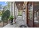 Charming covered porch featuring stone flooring, white columns, and an inviting seating area at 3016 Allansford Ln, Raleigh, NC 27613