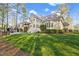 Expansive backyard with a well-maintained lawn, multiple outdoor living spaces, and mature trees at 3016 Allansford Ln, Raleigh, NC 27613