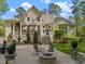 Beautiful rear exterior showcasing a covered deck, patio, fountain, and lush backyard at 3016 Allansford Ln, Raleigh, NC 27613