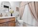 Well-lit bathroom featuring a vanity, toilet, and shower with a curtain at 304 Westgate Cir, Angier, NC 27501