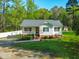 Charming one-story home featuring a front porch and a well-manicured front lawn with mature trees and landscaping at 304 Westgate Cir, Angier, NC 27501