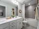 Modern bathroom with double sink vanity, stylish mirrors, and a tiled shower-tub combination at 306 White Magnolia Ln, Fuquay Varina, NC 27526