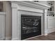 Elegant fireplace with a sleek black surround and marble hearth, built-in shelving on either side at 306 White Magnolia Ln, Fuquay Varina, NC 27526