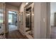 Hallway featuring hardwood floors, with view of a bedroom and a beautifully tiled standing shower at 306 White Magnolia Ln, Fuquay Varina, NC 27526
