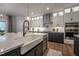Modern kitchen features pendant lights, quartz counters, stainless appliances, and stylish cabinetry at 306 White Magnolia Ln, Fuquay Varina, NC 27526