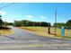 Scenic view of the lot featuring lush green trees and open field with a sales office in the distance at 306 White Magnolia Ln, Fuquay Varina, NC 27526