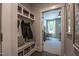 Mudroom with built-in bench, storage hooks, and basket shelving, with view into a bedroom at 306 White Magnolia Ln, Fuquay Varina, NC 27526