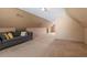 Attic space featuring angled ceilings, carpet, a comfortable couch, and unique wall decor at 310 Cedarhurst Ln, Franklinton, NC 27525
