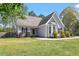 Quaint one-story home with gray siding, black shutters, and green grass at 310 Cedarhurst Ln, Franklinton, NC 27525