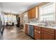 This cozy kitchen features a stainless steel dishwasher, a sink beneath a window, and hardwood floors at 310 Cedarhurst Ln, Franklinton, NC 27525