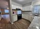 Open kitchen featuring white cabinetry, granite countertops, hardwood floors and stainless steel appliances at 3109 Cinnamon Circle Cir, Raleigh, NC 27610