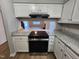 Open kitchen with modern black appliances, granite countertops, and white cabinets at 3109 Cinnamon Circle Cir, Raleigh, NC 27610