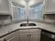 Corner kitchen sink area with white cabinets, granite counters, and shuttered windows at 3109 Cinnamon Circle Cir, Raleigh, NC 27610