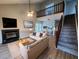 Bright living room with fireplace, neutral walls, ceiling fan, and stairway to the second story loft at 3109 Cinnamon Circle Cir, Raleigh, NC 27610