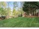 Lush backyard with mature trees and a charming playhouse area at 317 Okamato St, Raleigh, NC 27603