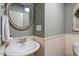 Charming bathroom features a round mirror, pedestal sink, and lovely beadboard paneling at 317 Okamato St, Raleigh, NC 27603