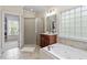 Luxurious bathroom with a large tub, glass-enclosed shower, and natural light at 317 Okamato St, Raleigh, NC 27603