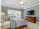 Inviting bedroom showcasing a tray ceiling, a ceiling fan and large bright windows at 317 Okamato St, Raleigh, NC 27603