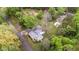 Aerial view of a wooded property features a home with a metal roof at 323 Coral Ave, Goldston, NC 27252
