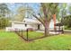 Fenced backyard with mature trees, lush lawn, and a patio area at 323 Coral Ave, Goldston, NC 27252