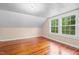 Sunny bedroom features hardwood floors, fresh paint, and double windows at 323 Coral Ave, Goldston, NC 27252
