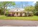 Charming two-story home with a metal roof, inviting front porch, and beautifully landscaped front yard at 323 Coral Ave, Goldston, NC 27252