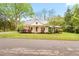Charming two-story home with a metal roof, inviting front porch, and beautifully landscaped front yard at 323 Coral Ave, Goldston, NC 27252