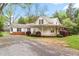 Charming home with manicured lawn, metal roof, covered porch, and gravel driveway at 323 Coral Ave, Goldston, NC 27252