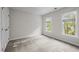 Bright bedroom with carpeted floors, white walls, two windows and a closet at 3514 Shady Creek Dr, Durham, NC 27713