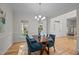 Bright dining room with hardwood floors, modern chandelier, and views of the front yard at 3514 Shady Creek Dr, Durham, NC 27713