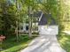 Traditional white home with a lush, wooded landscape and a long driveway at 3514 Shady Creek Dr, Durham, NC 27713