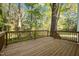 A wooden deck offers a view of the backyard with mature trees and green space at 3514 Shady Creek Dr, Durham, NC 27713