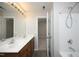 Bright bathroom featuring a double sink vanity, walk-in shower, and doorway to another room at 3623 Bison Hill Ln, Raleigh, NC 27604