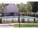 Community pool area surrounded by black metal fencing, landscaping, and residential buildings at 3623 Bison Hill Ln, Raleigh, NC 27604