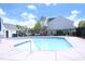 Community pool with light blue water surrounded by a concrete deck and black metal fencing at 3623 Bison Hill Ln, Raleigh, NC 27604
