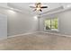 Spacious bedroom with a tray ceiling, ceiling fan, neutral paint, and a large window at 40 Holden Ct, Youngsville, NC 27596