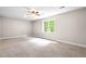 This bright bedroom features neutral tones, a window, a ceiling fan, and plush carpeting at 40 Holden Ct, Youngsville, NC 27596