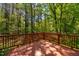 View of the spacious wooden deck surrounded by lush greenery and tall trees at 40 Holden Ct, Youngsville, NC 27596