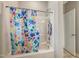 Clean bathroom featuring a shower with a colorful floral curtain and wall storage at 403 Lagoon Ln, Mebane, NC 27302