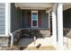 Inviting front porch with stone detailing, and a cozy seating area with chairs and a small table at 403 Lagoon Ln, Mebane, NC 27302
