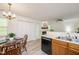 Eat-in kitchen with stainless steel sink, black dishwasher, light wood cabinets, and a dining table at 407 Gooseneck Dr # A2, Cary, NC 27513