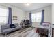 Cozy bedroom with wood-look flooring, large windows, comfortable seating, and ample natural light at 421 Long Lake Dr, Fuquay Varina, NC 27526