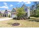 Landscaped front yard showing a two-story home with neutral siding and a stone-accented garage at 421 Long Lake Dr, Fuquay Varina, NC 27526