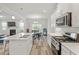 Bright kitchen boasts white cabinetry, stainless steel appliances, and an eat-in dining area with natural light at 421 Long Lake Dr, Fuquay Varina, NC 27526